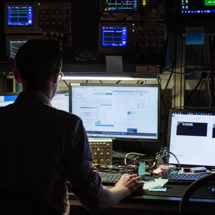 student on computer in dark room